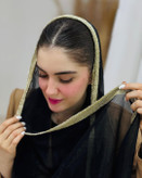 نمای نزدیک شال حریر شاین زنانه با حاشیه طلایی روی سر مدل، نمایش بافت و درخشندگی شال