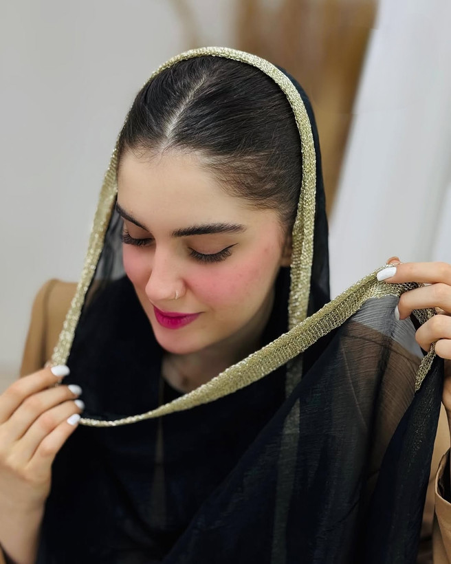نمای نزدیک شال حریر شاین زنانه با حاشیه طلایی روی سر مدل، نمایش بافت و درخشندگی شال